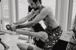 Dancer stretching and warming up by the window in a dance studio.