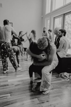 Dancers moving expressively on a wooden floor during an intimate dance workshop.