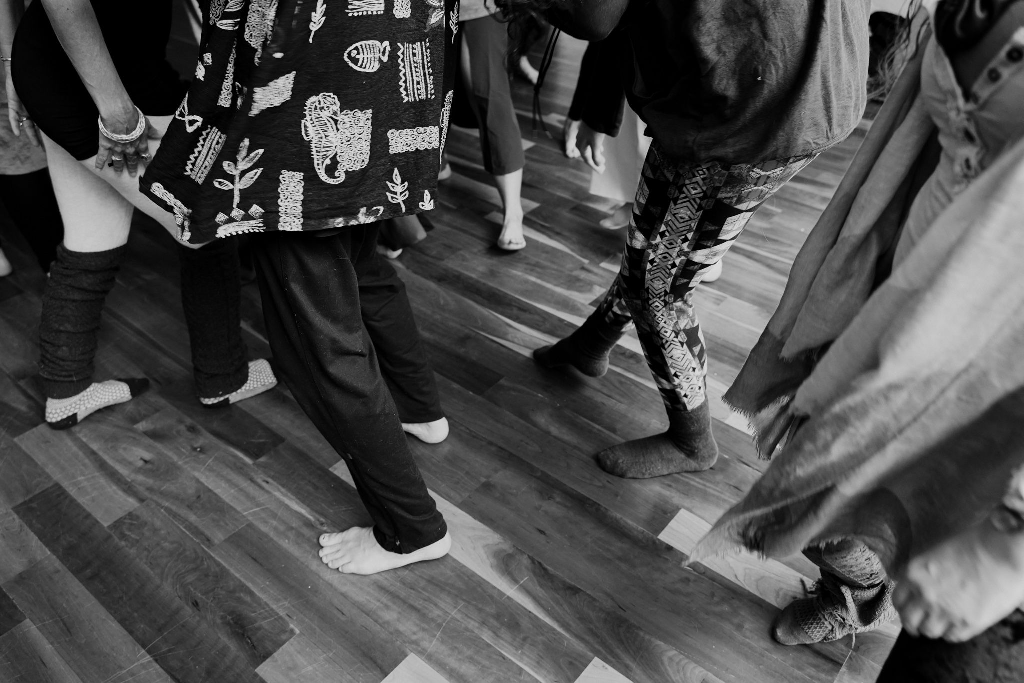 Low angle shot of dancers' feet and legs on wooden floor during an event.