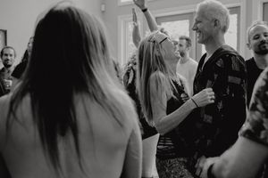 Black and white candid shot of people interacting at a social gathering.