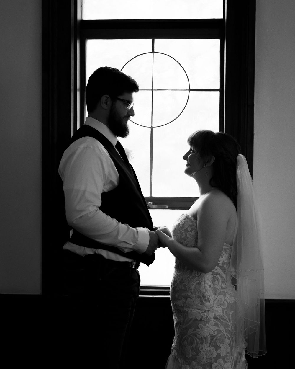 A black and white silhouette of a couple dancing together near a window, creating a romantic atmosphere.