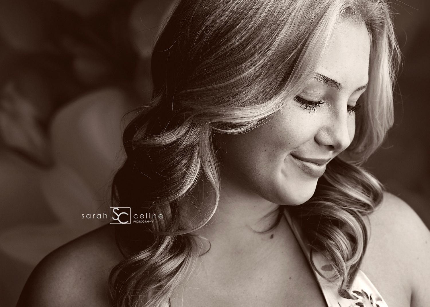 A series of black and white portraits showing someone in a formal dress with flowing hair looking down and smiling.