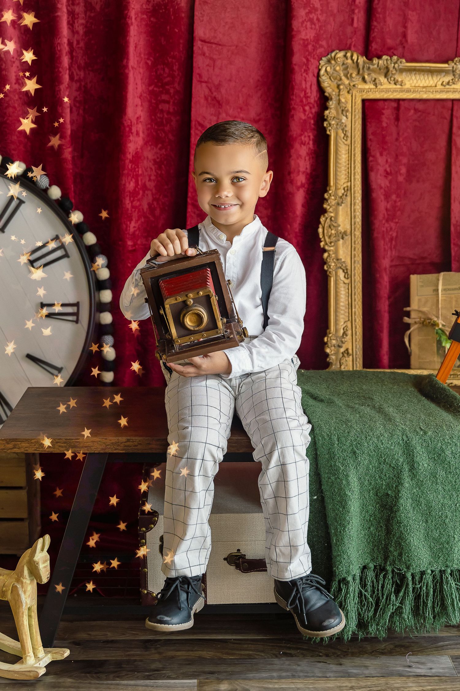 child holds a vintage camera for photography