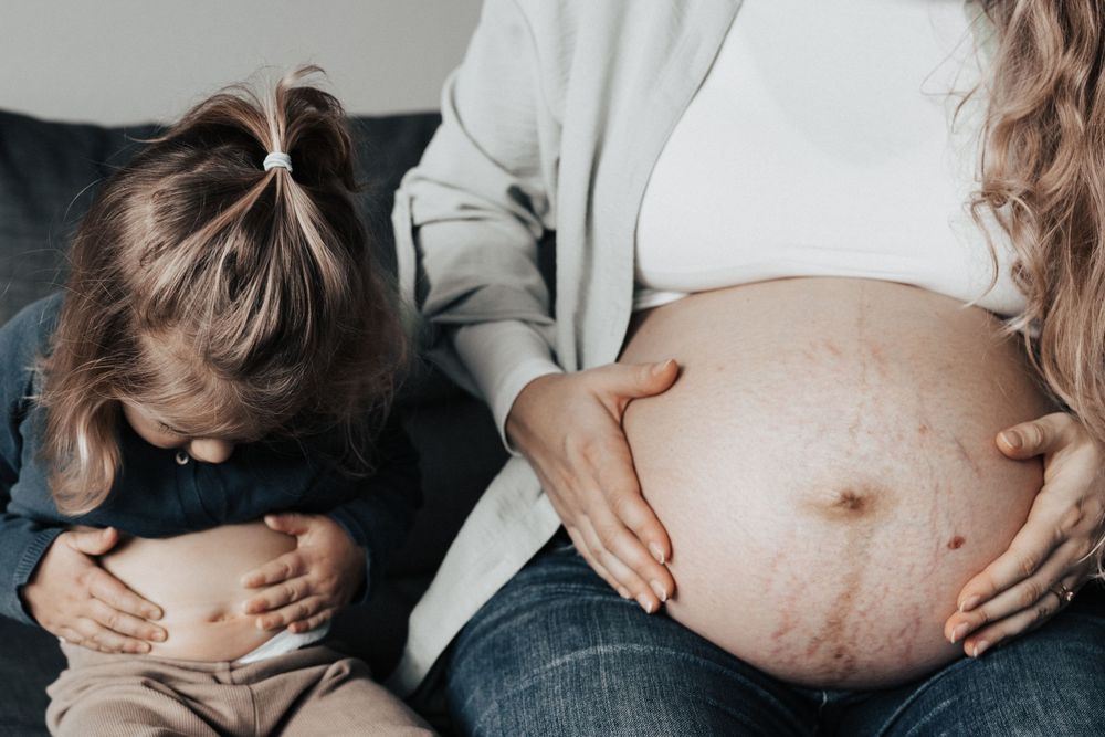 Mutter und Tochter zeigen Ihre Bäuche