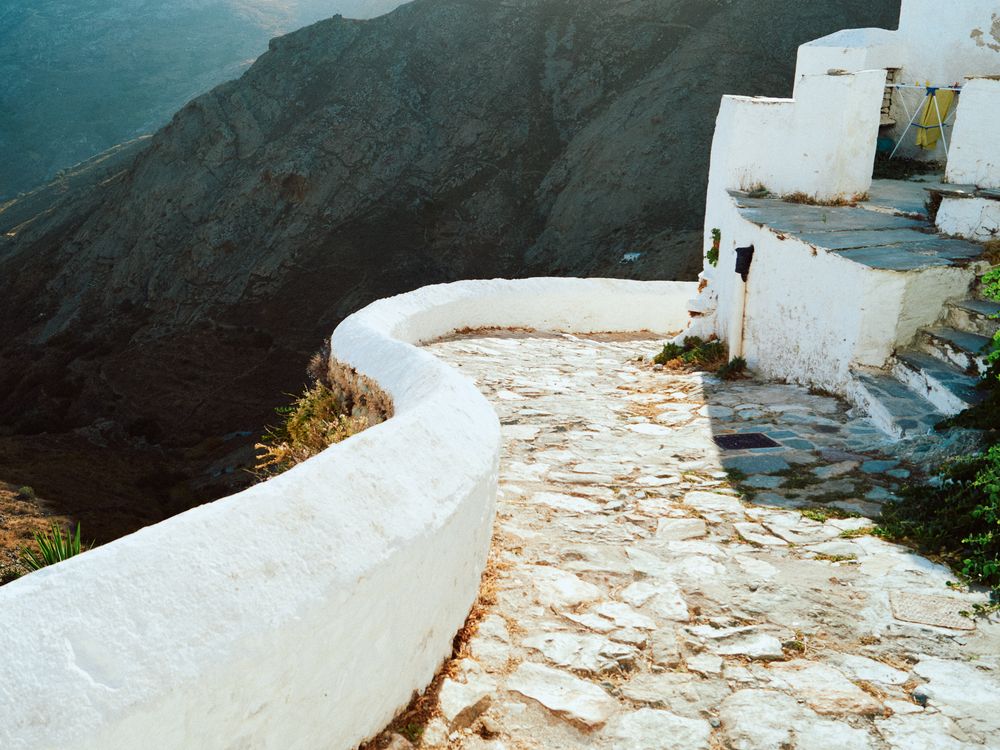 Curved stone path along whitewashed buildings in the mountains