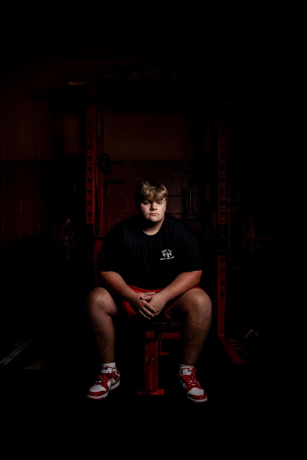 A dramatic dark portrait series showing someone seated on a red chair in moody lighting.