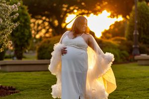 Ethereal white dress twirling against golden sunset light in a garden setting.