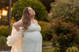 White dress movement captured in a garden with blooming flowers at dusk.