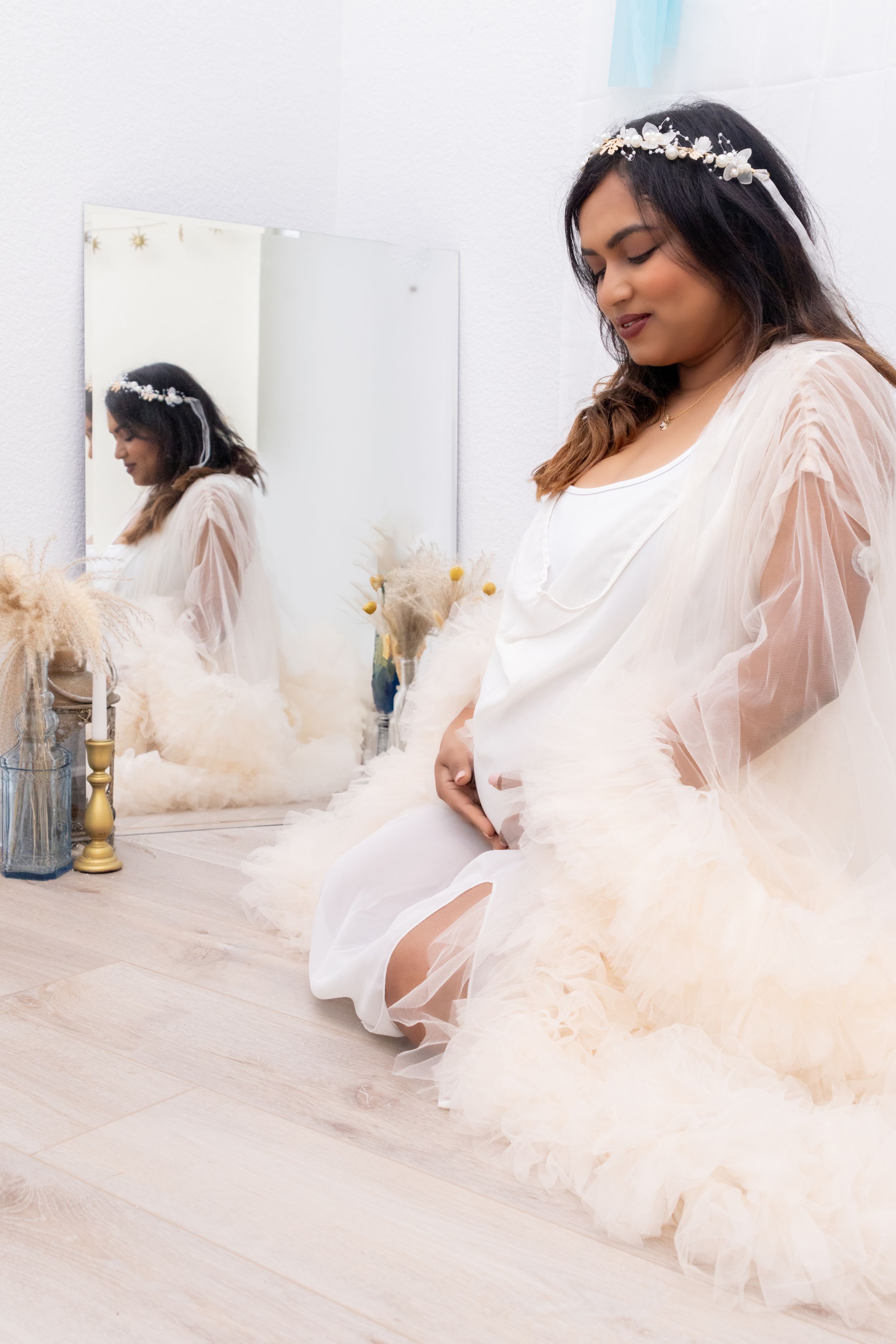 Romantic peach tulle dress photographed against white studio backdrop.