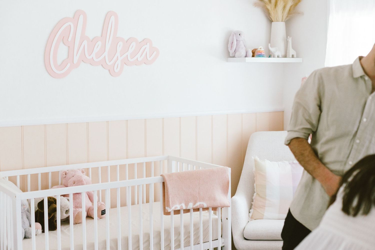 Pink nursery room with white crib and name decor on the wall.