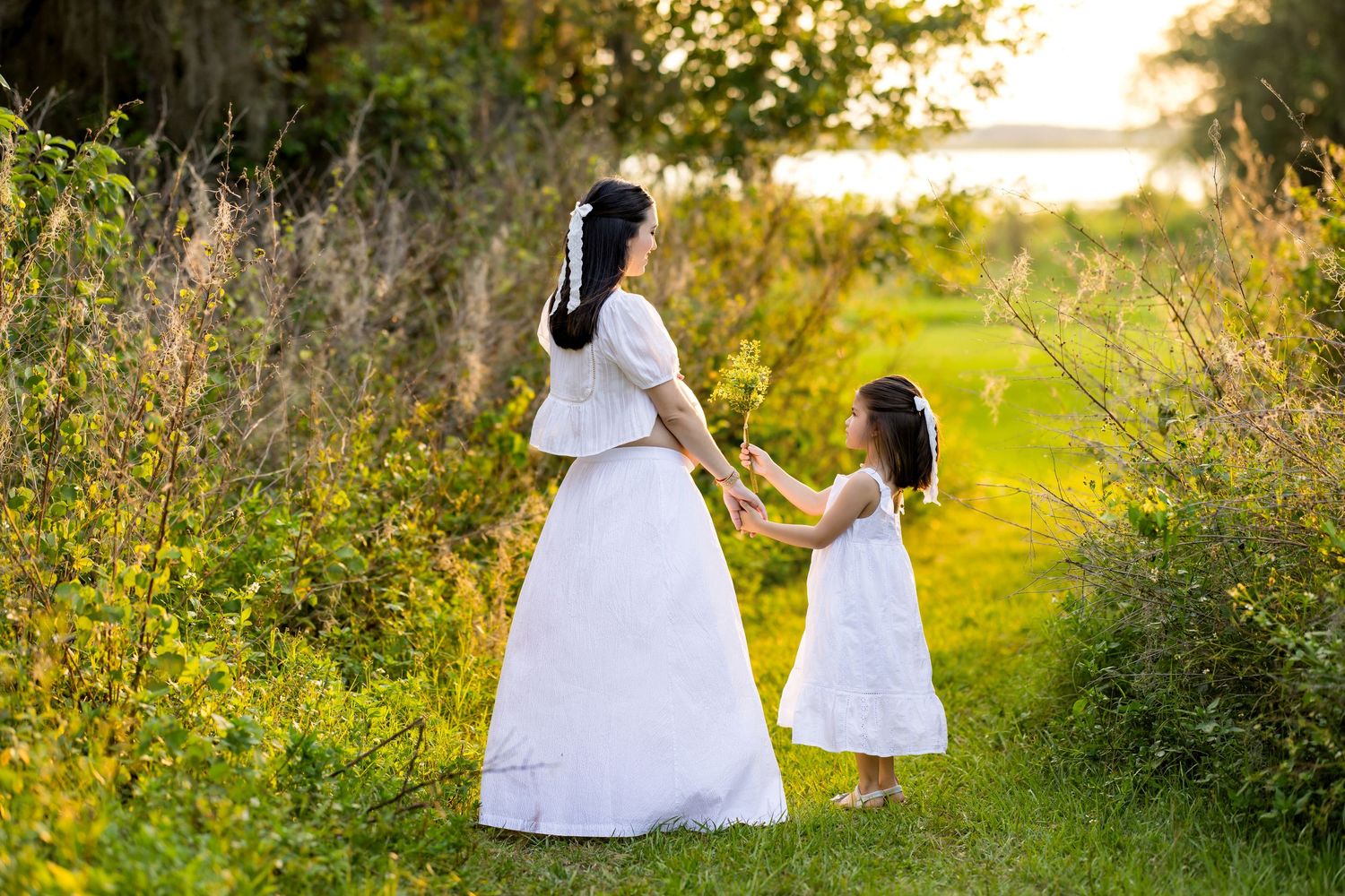 Young girls in white dresses running through a sunlit field. Photo by Dani De La Rosa, DigitalMyst Photography, Wesley Chapel Florida