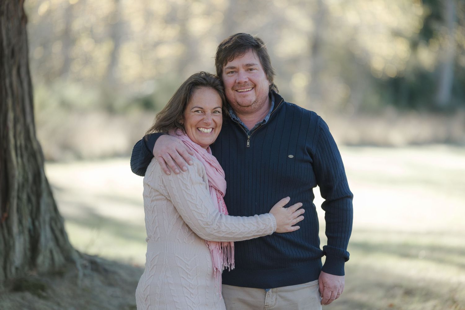 married couple posing for family photo in autumn