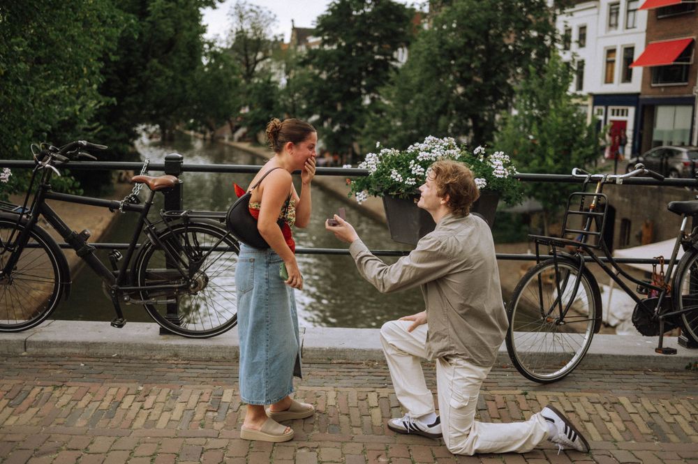 Couple enjoying a romantic moment on a cobblestone street with bicycles in the background.