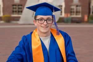 Male Boise State University graduate close up wearing cap and gown