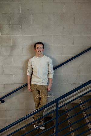 Male Boise State University graduate wearing street clothes in stairwell at Brady garage