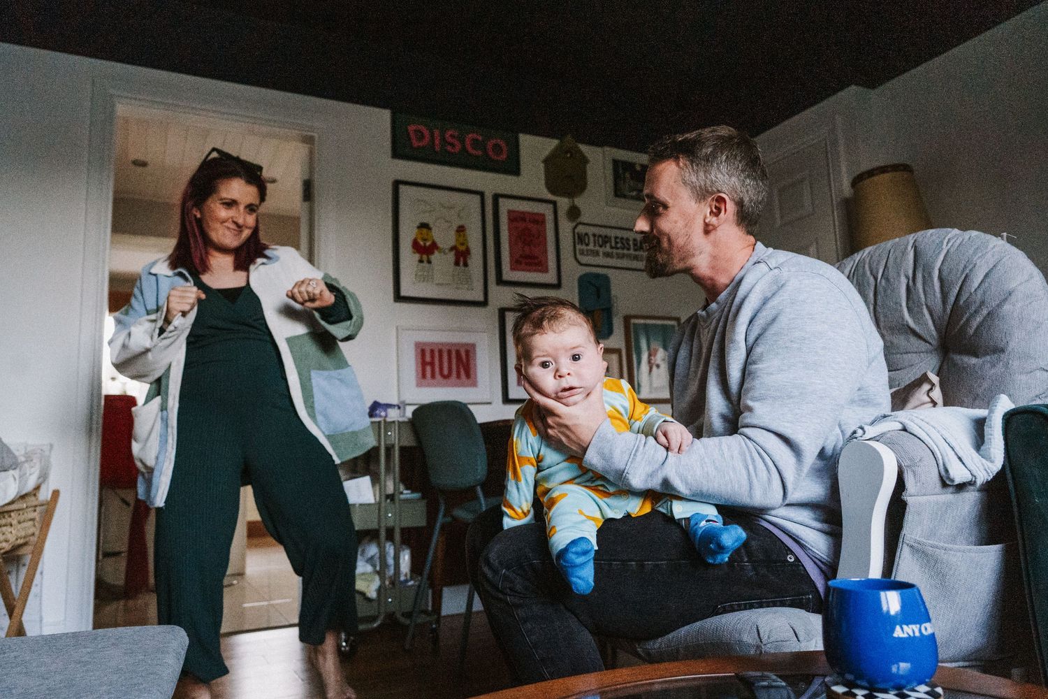 A parent and child play together with toys while sitting on a couch in a living room.