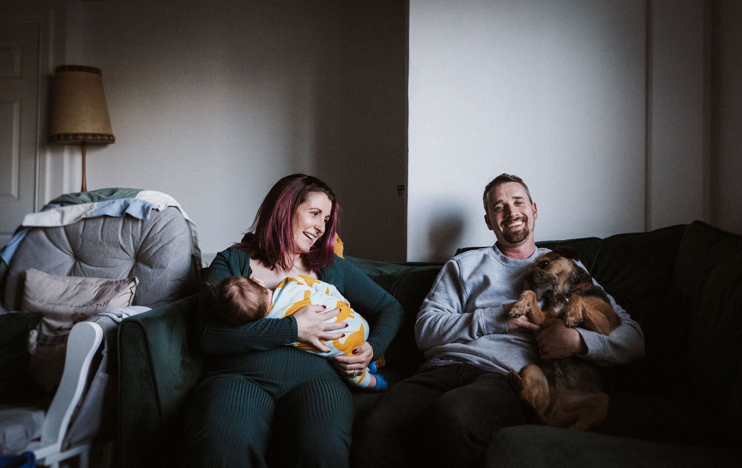 A tender moment shared between two people lounging together on a dark gray couch.