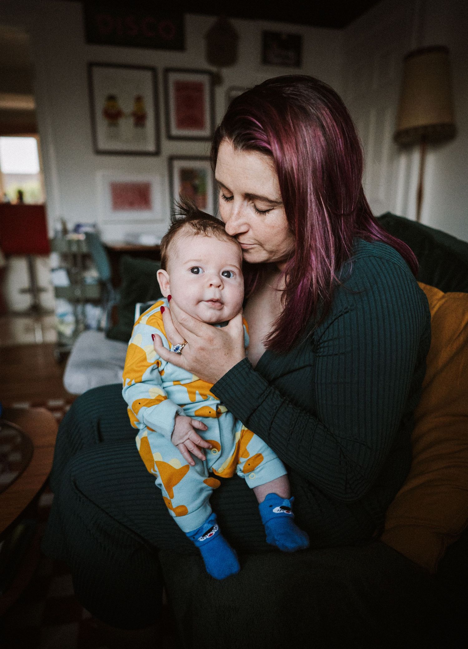 A collection of intimate color photographs capturing playful interactions between parent and infant in a dimly lit room.