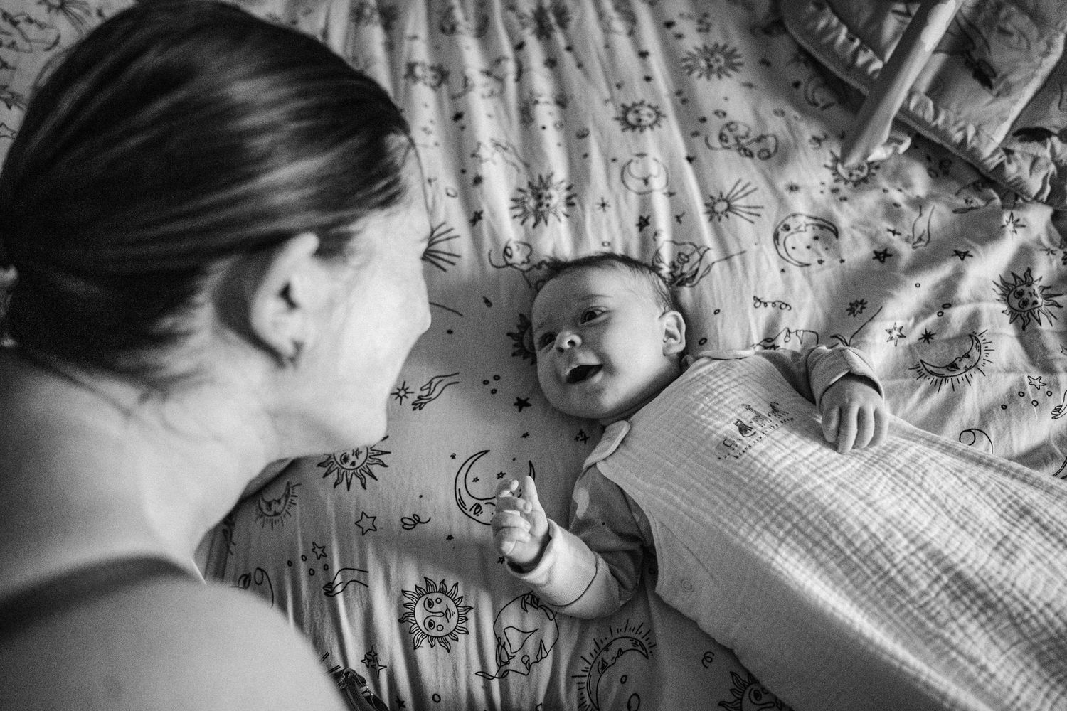 Series of black and white images showing a sleeping baby on textured blankets.