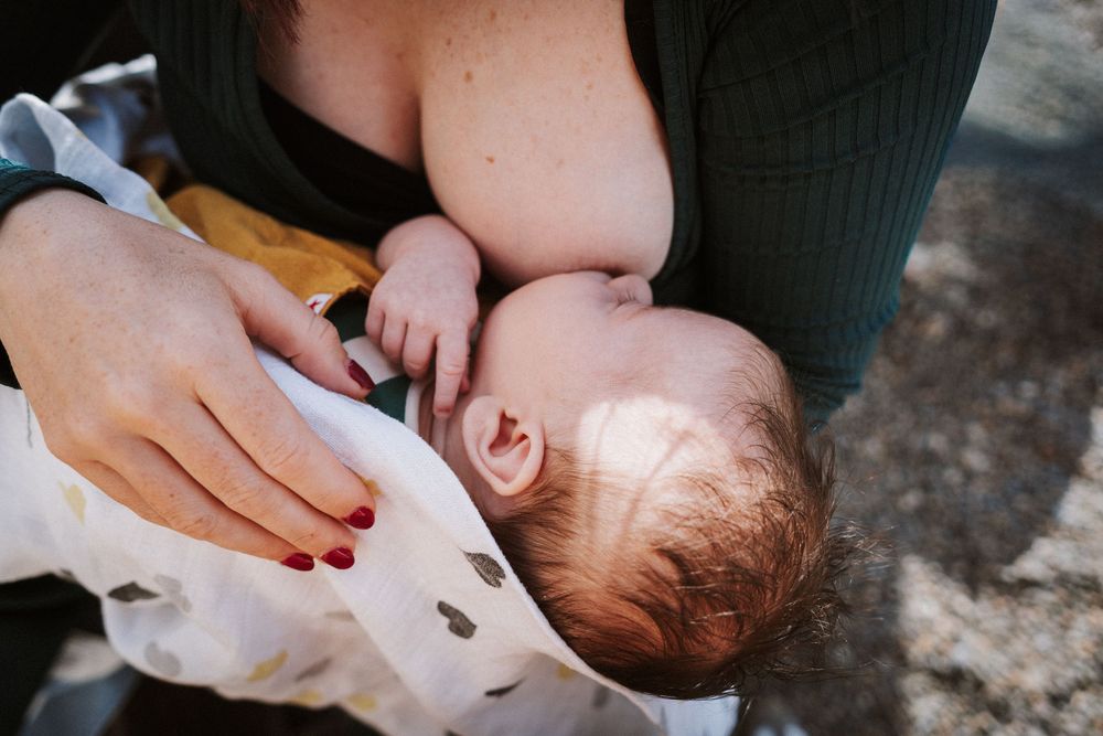 A mother holds and comforts her crying newborn baby in a series of tender close-up shots.
