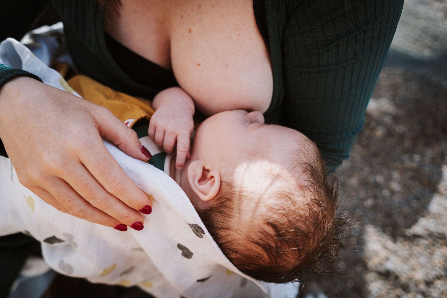 A mother holds and comforts her crying newborn baby in a series of tender close-up shots.