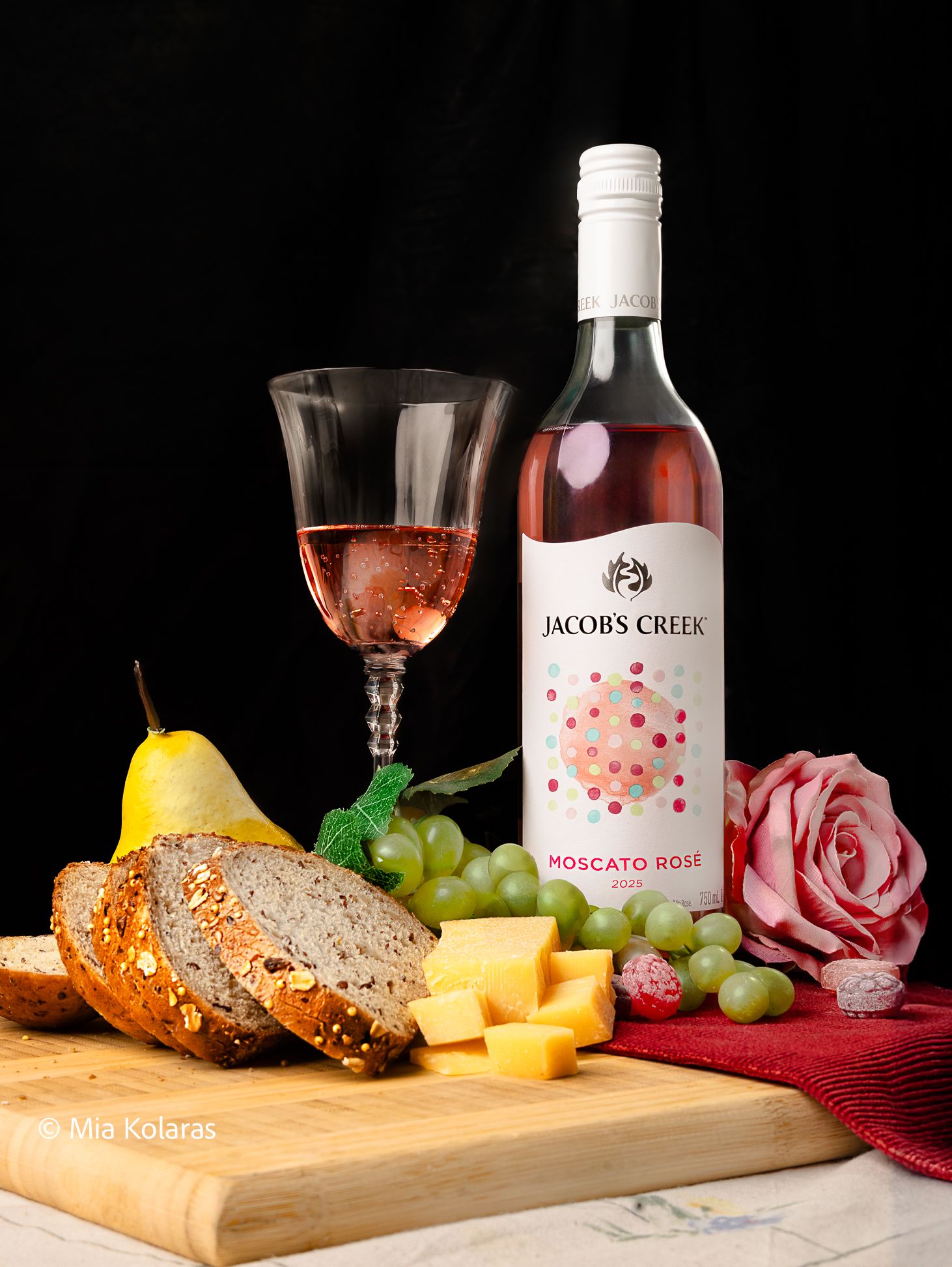 Jacobs Creek Wine Bottle paired with Cavendish & Harvey candy, Stonemill Canada Bread, and Dubliner Cheese with grapes, & wine glass