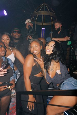 Group of friends smiling and posing together at a lively nightclub party event.
