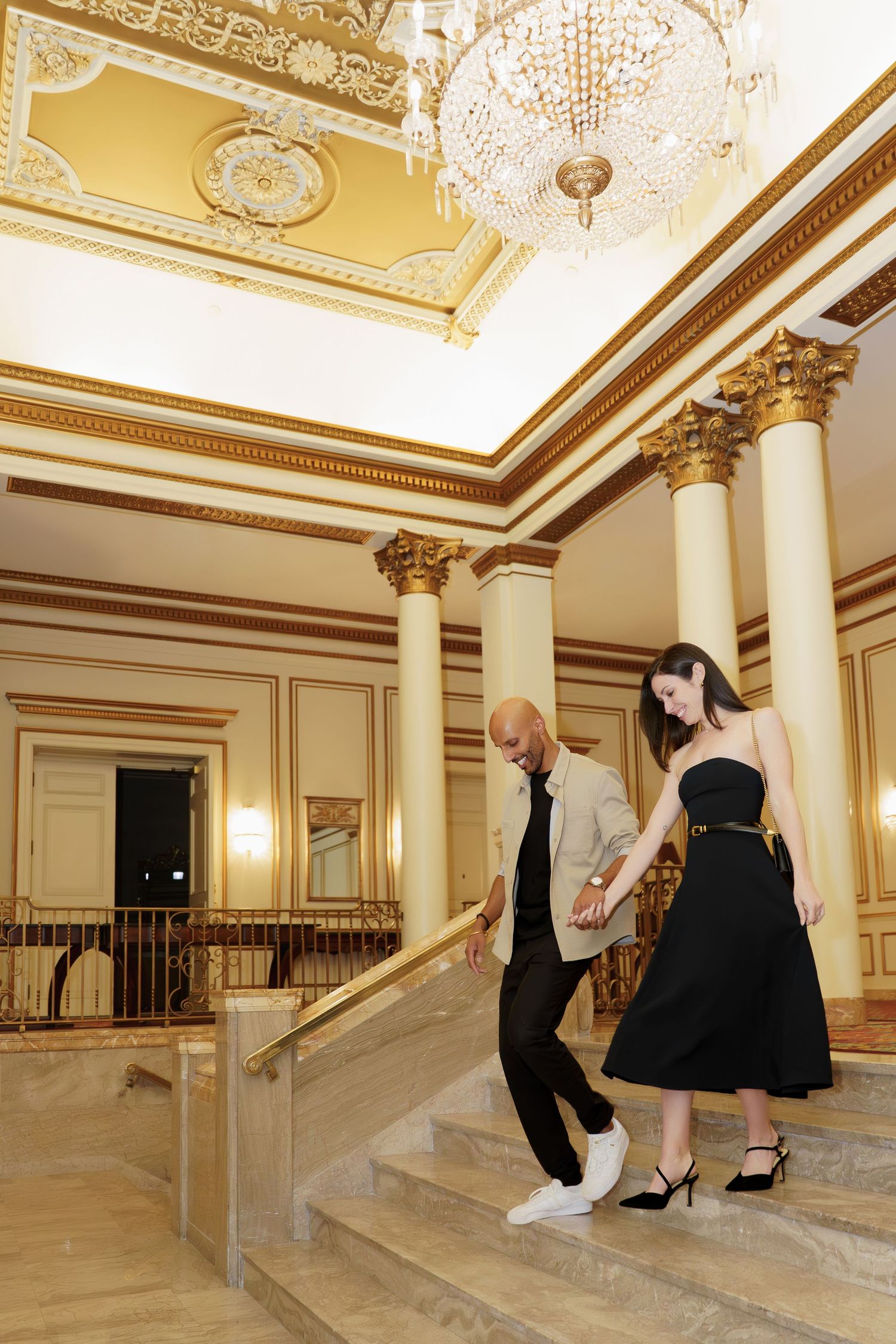 Sequence of photos showing people walking up ornate marble stairs in an elegant historic building with gilded ceiling details.