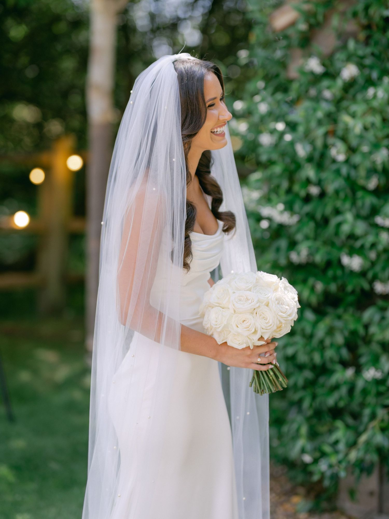 Black and white wedding photos show a couple laying on the ground in formal attire under an elegant chandelier.