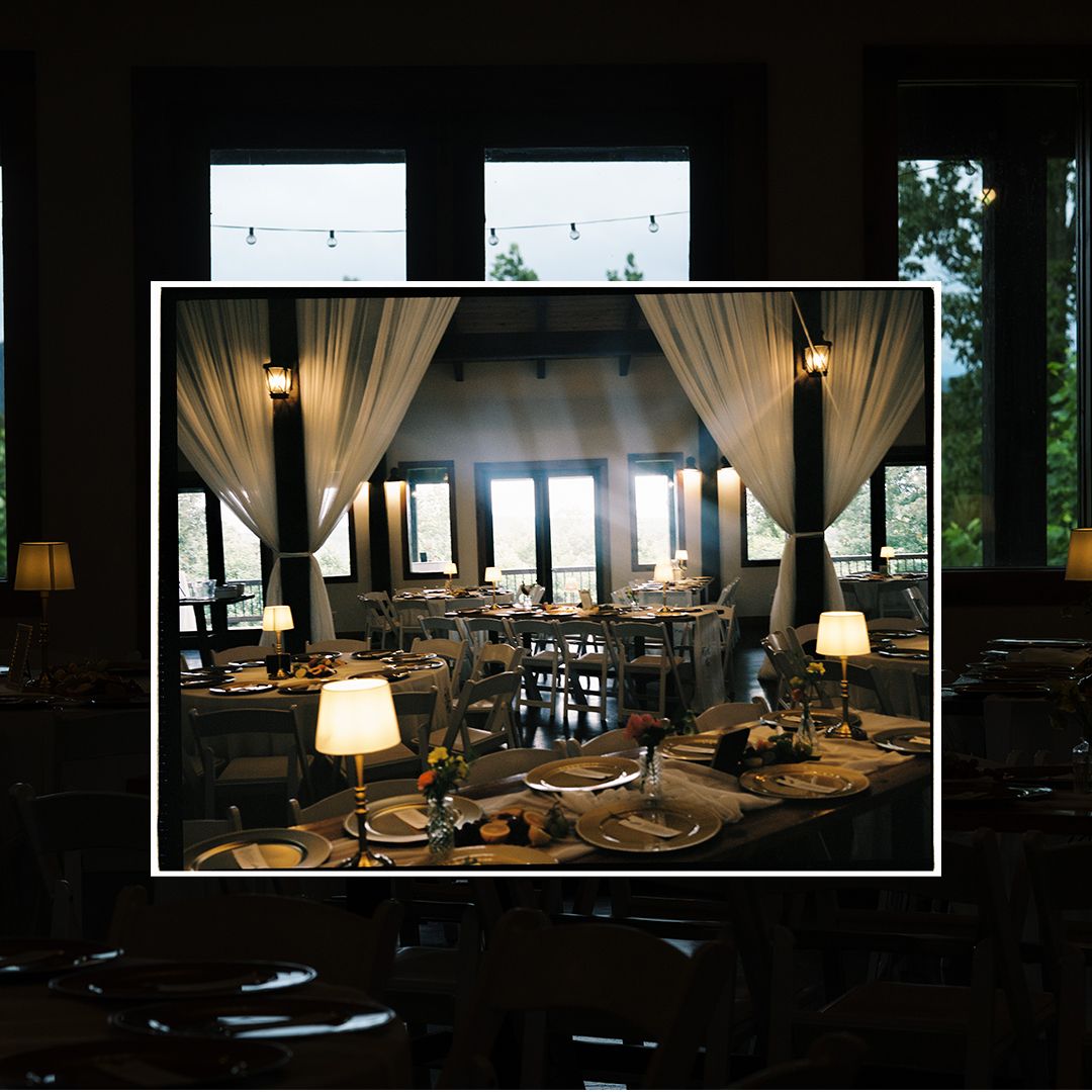 Elegant restaurant interior with sheer curtains, table settings and warm lighting creating an intimate dining atmosphere.
