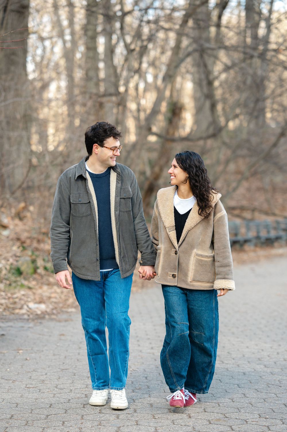 A couple in casual attire walks hand in hand along a wooded path in three sequential photos.