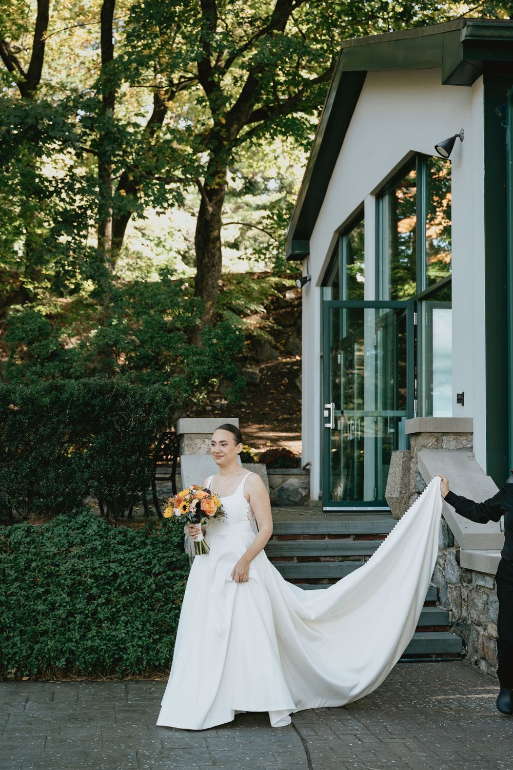 A series of wedding photos showing a bride with her dress flowing against a white building with green landscaping.