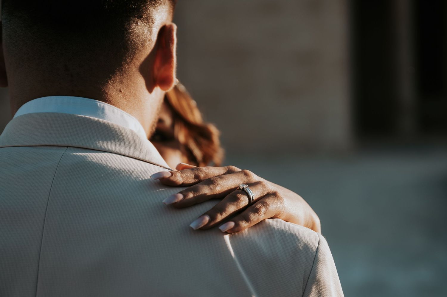 Close-up shot of hands exchanging wedding rings during an outdoor ceremony.