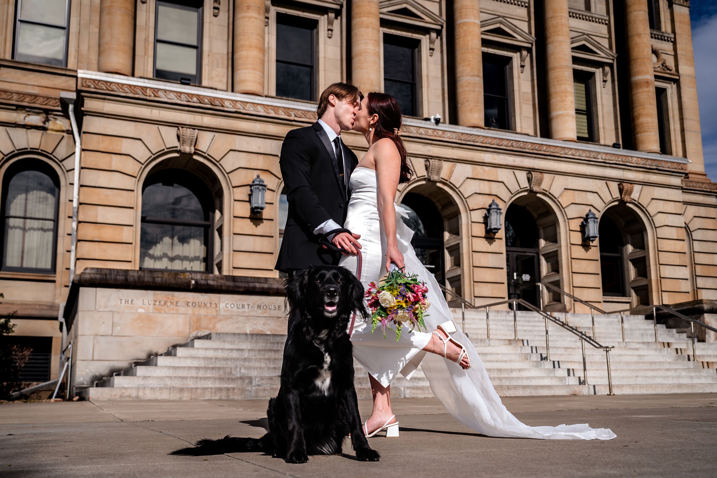 Wedding photos taken on wide stone steps of historic government building with classical architecture.