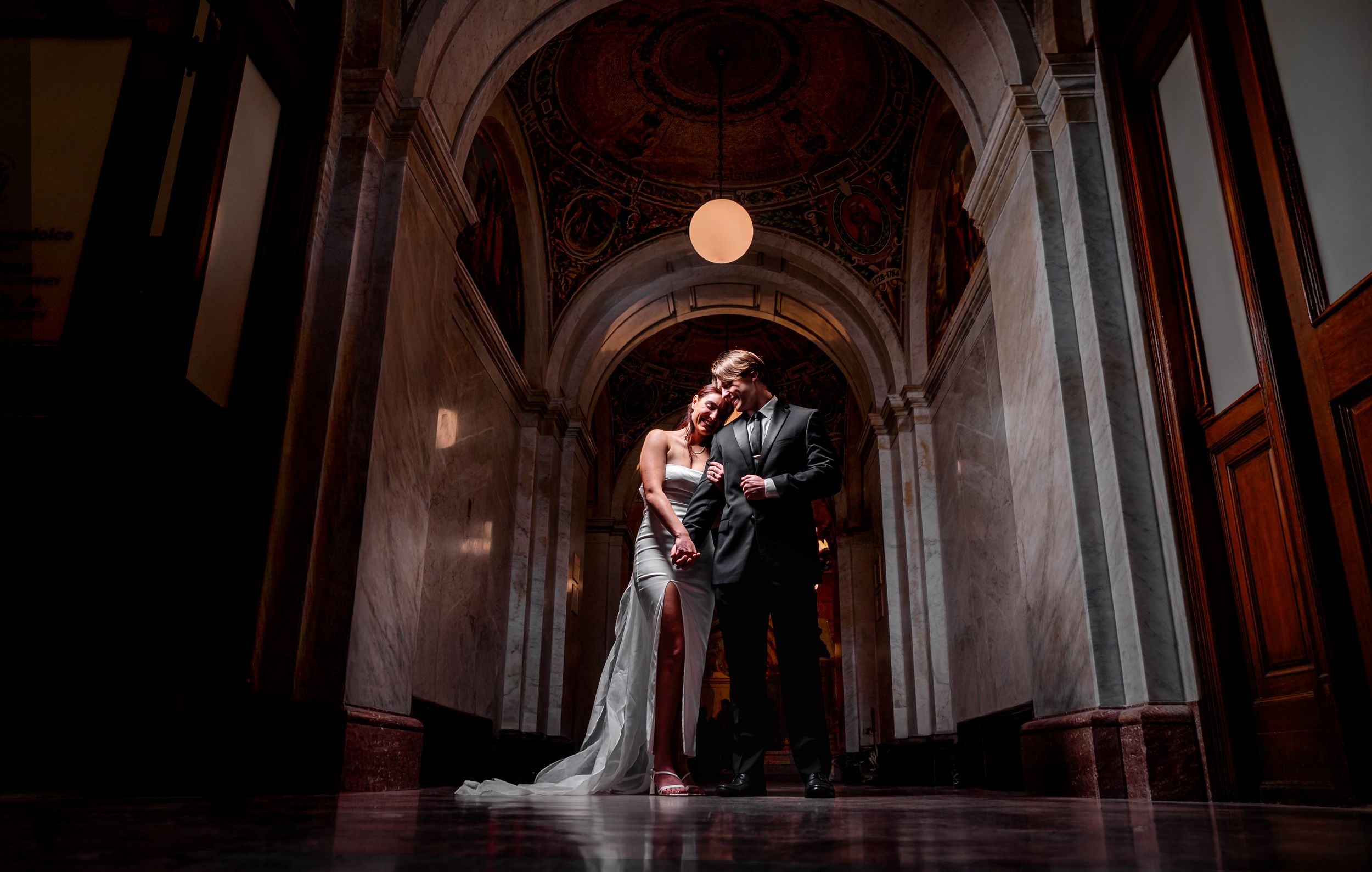 A romantic wedding photo series showing couples in dramatic lighting against ornate architectural backdrops.