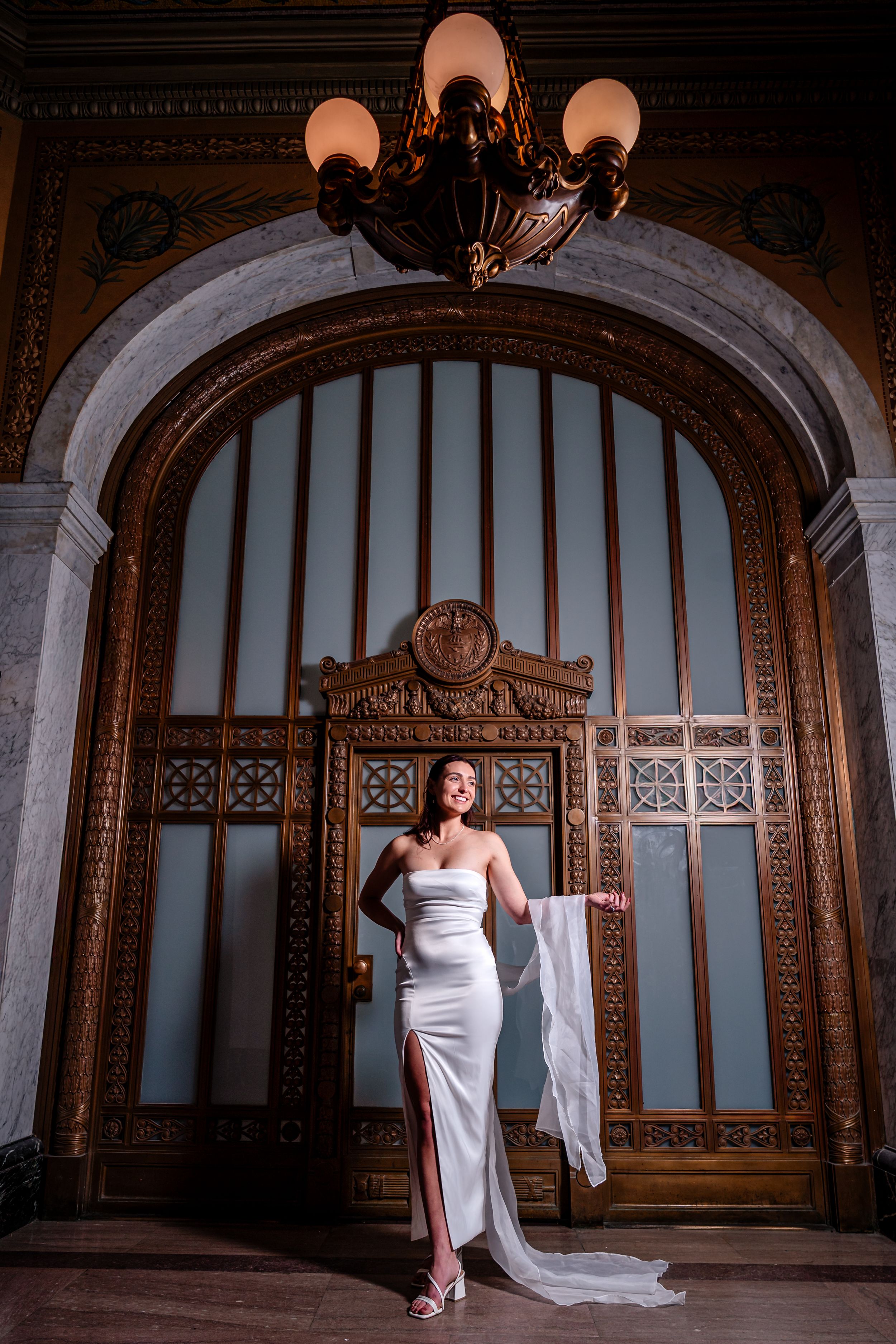Elegant bridal portraits in a historic venue with ornate woodwork and dramatic lighting.