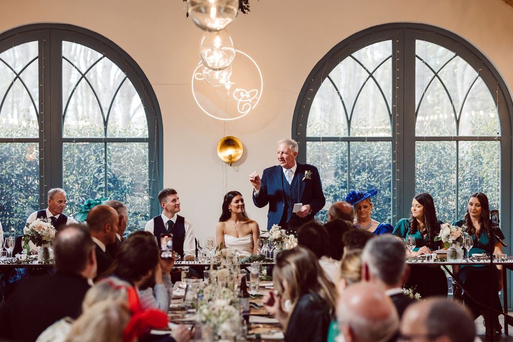Elegant wedding reception venue with arched windows and ambient lighting creates a romantic atmosphere.