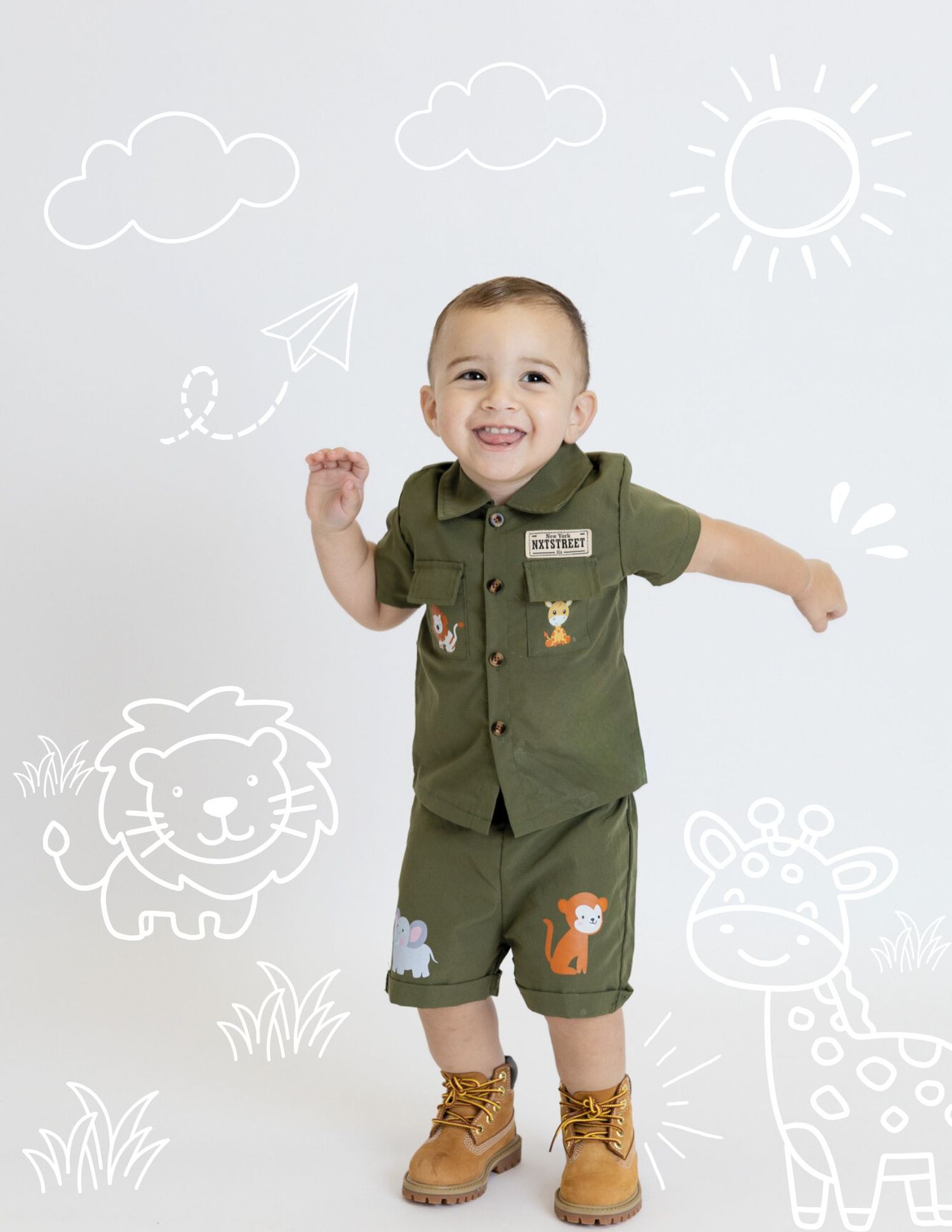 Playful toddler in safari ranger outfit standing against white backdrop with whimsical animal doodle illustrations.