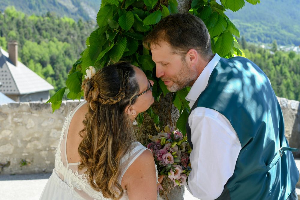 Mariés dans un décor alpin, partageant un instant intime face aux montagnes, photographie douce et poétique bylovephoto.