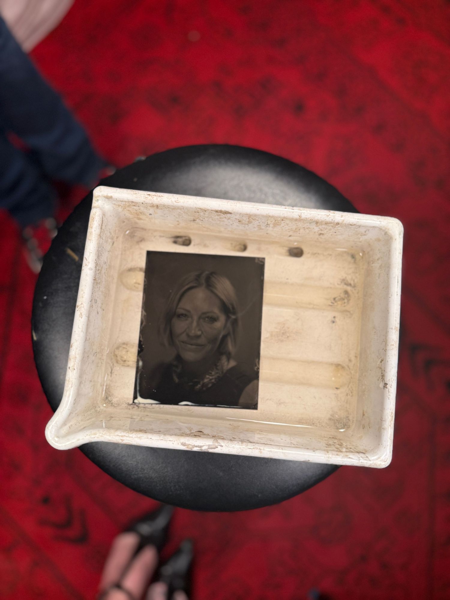 A series of old photographic negatives displayed on a dark red background with dramatic lighting.