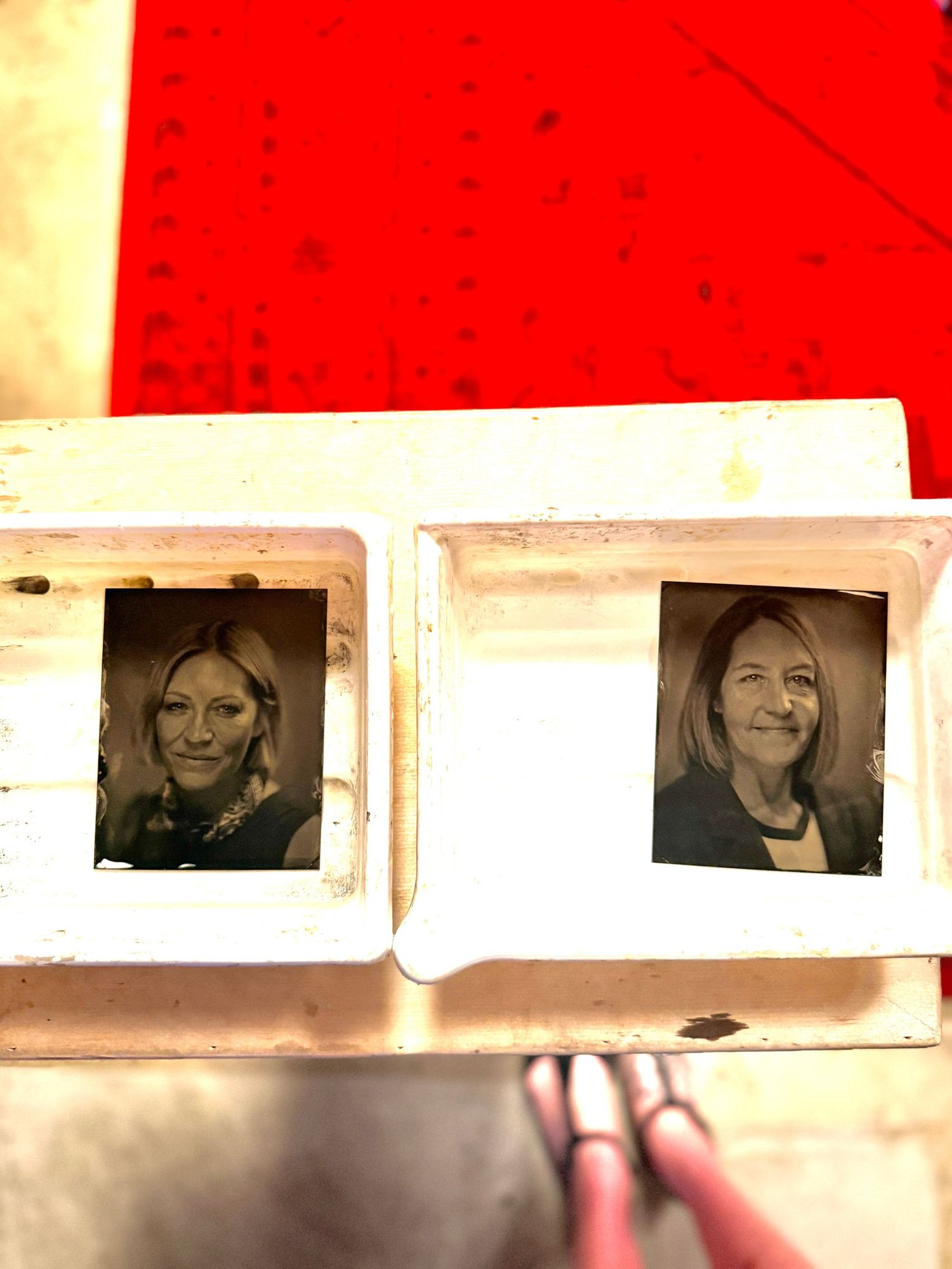 A row of vintage photo slides displayed on a light table with a bright red background illuminating the frames.
