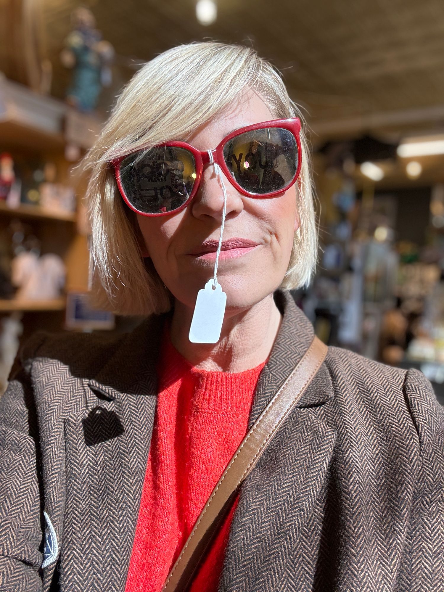 Person in red sweater and brown blazer wearing pink sunglasses shown in multiple sequential shots.