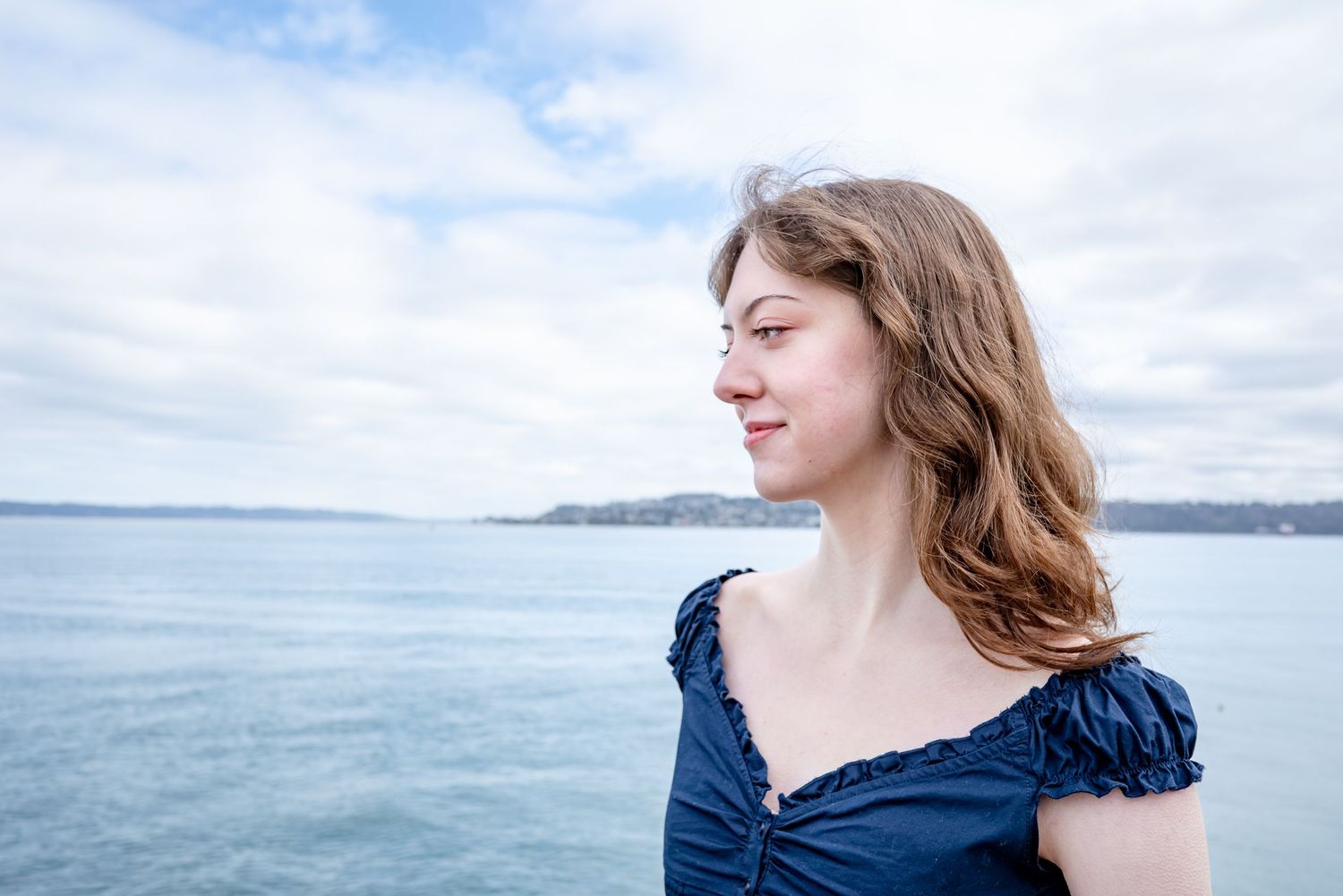 Close-up graduation portrait with water background in Tacoma Washington