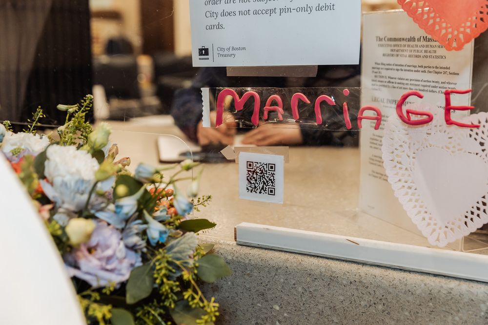 Close-up of a window with Marriage written in red letters, featuring a QR code and floral decorations.