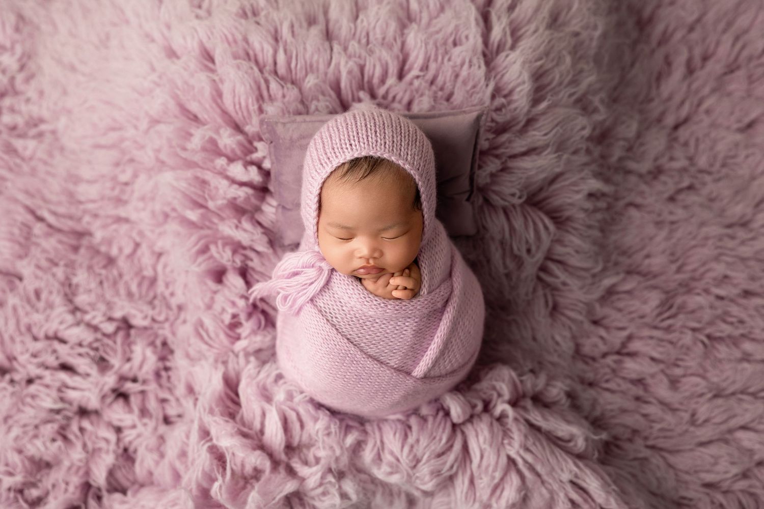 Newborn photography collage with soft pink fur blanket showing sleeping baby in various peaceful poses.