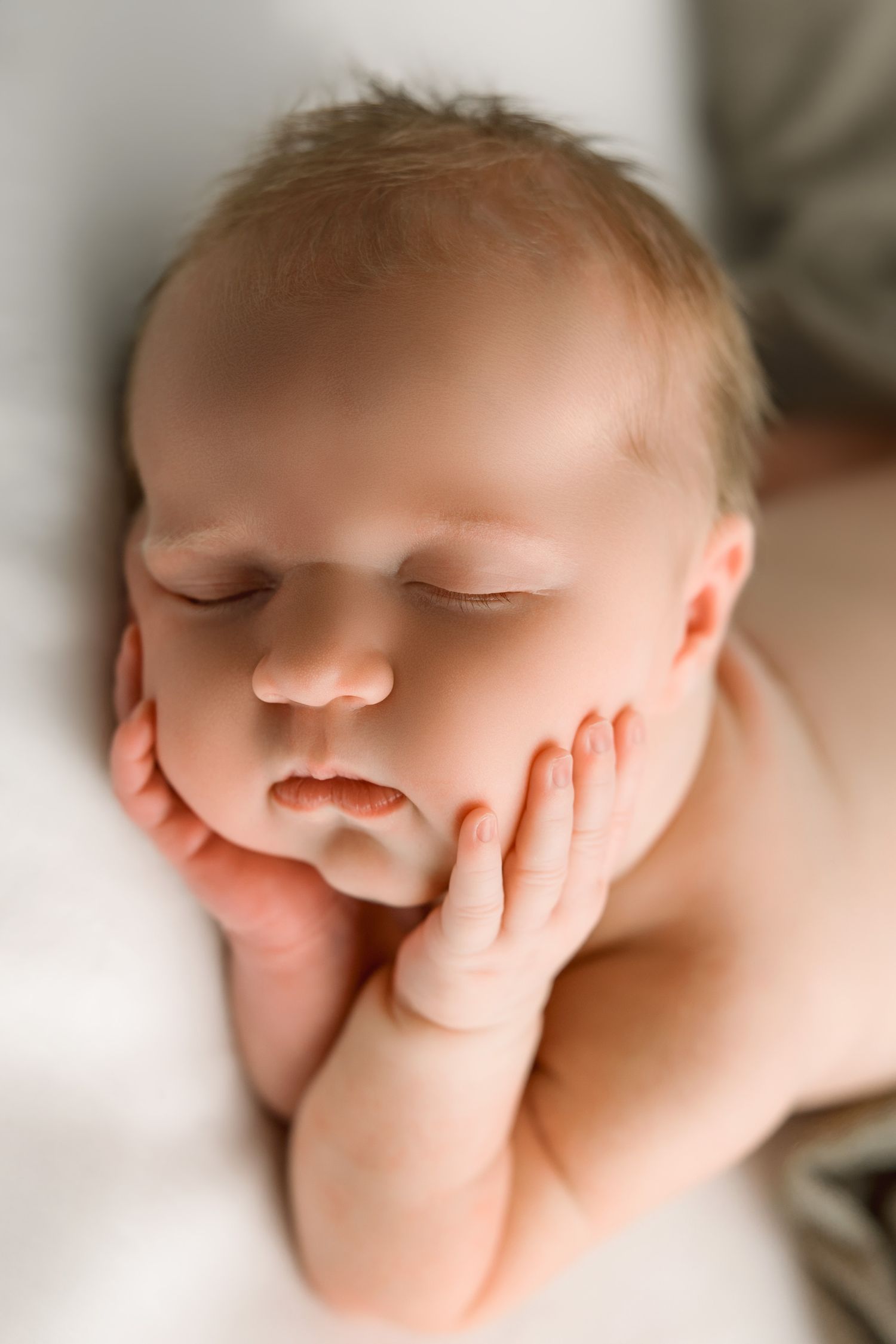 A sleeping baby's face shown in multiple close-up views with their tiny hand resting near their mouth.