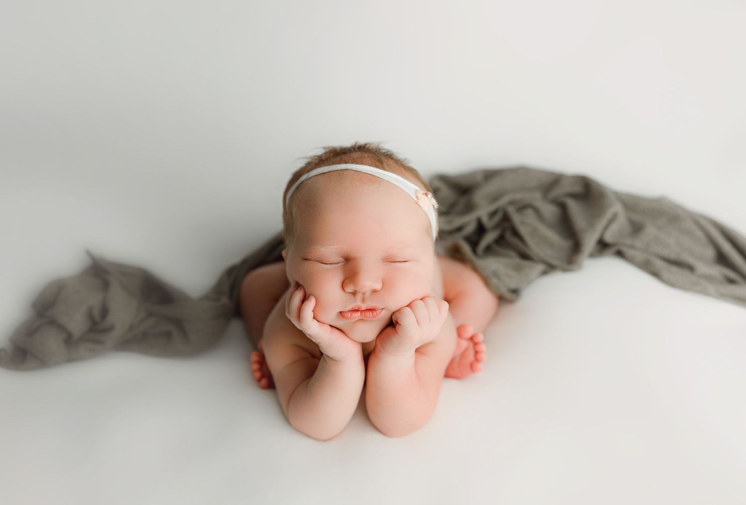 A series of minimalist black and white photographs showing tiny newborn baby feet against a light background.