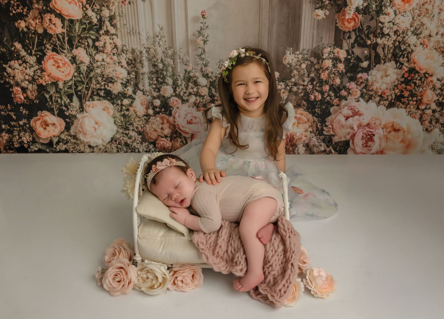 A series of soft, romantic newborn photography portraits set against a floral backdrop with pink and cream tones.