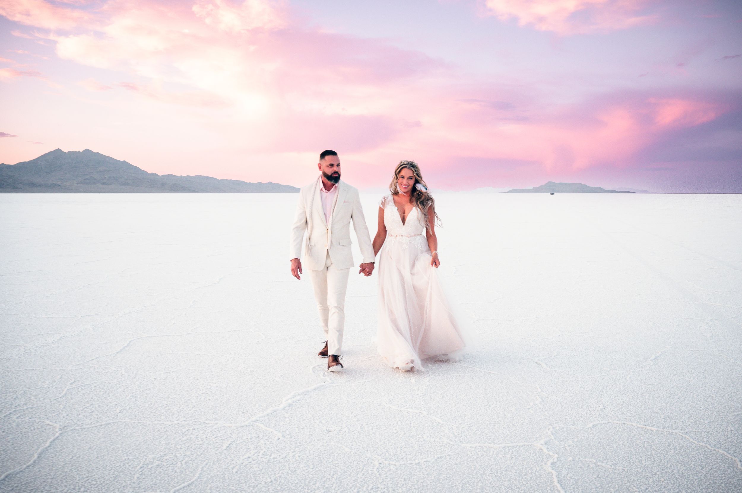 A small elopement on the salt flats with mountains in the distance at sunset. Salt flats elopement wedding photographer
