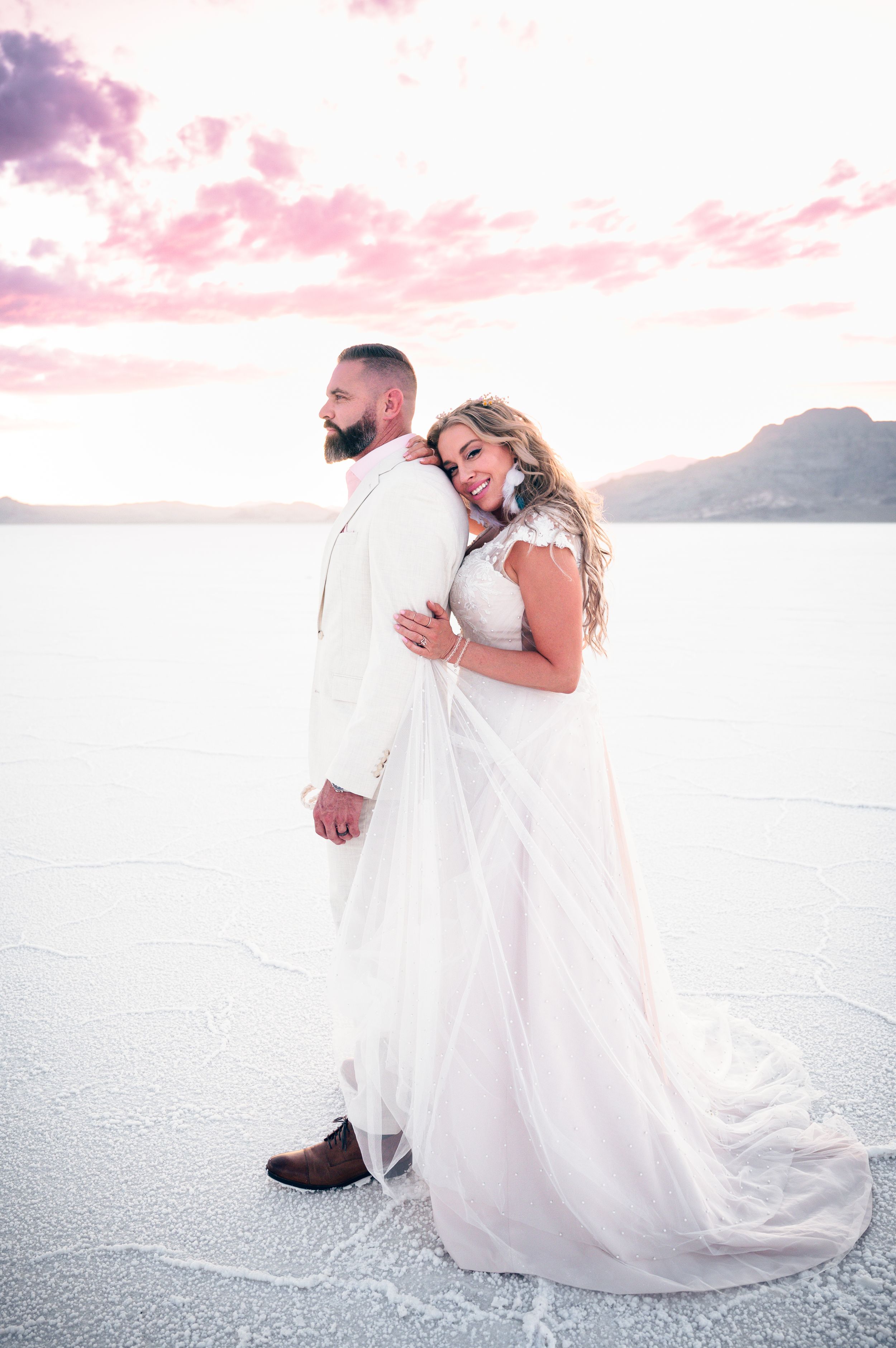 A small elopement on the salt flats with mountains in the distance at sunset. Salt flats elopement wedding photographer. Couples photography